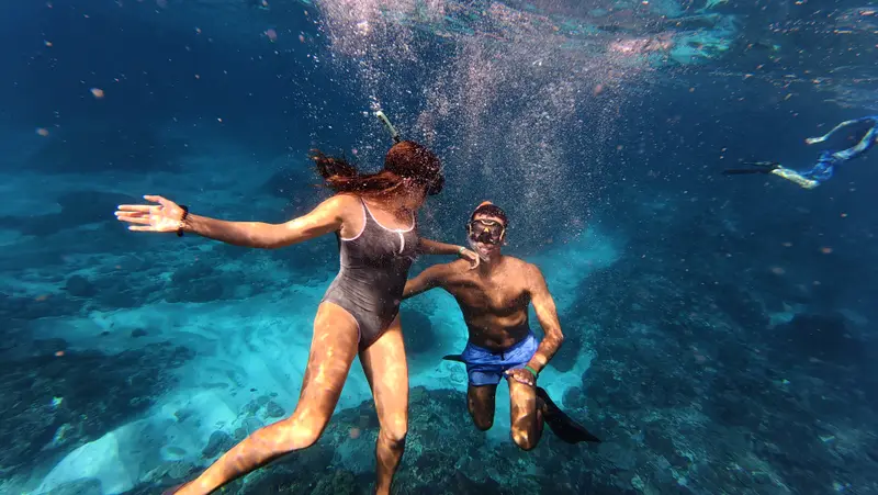Couple snorkeling in turquoise water at Crystal Bay, Nusa Penida